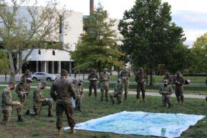 ROTC cadets gathered by a map outline. 